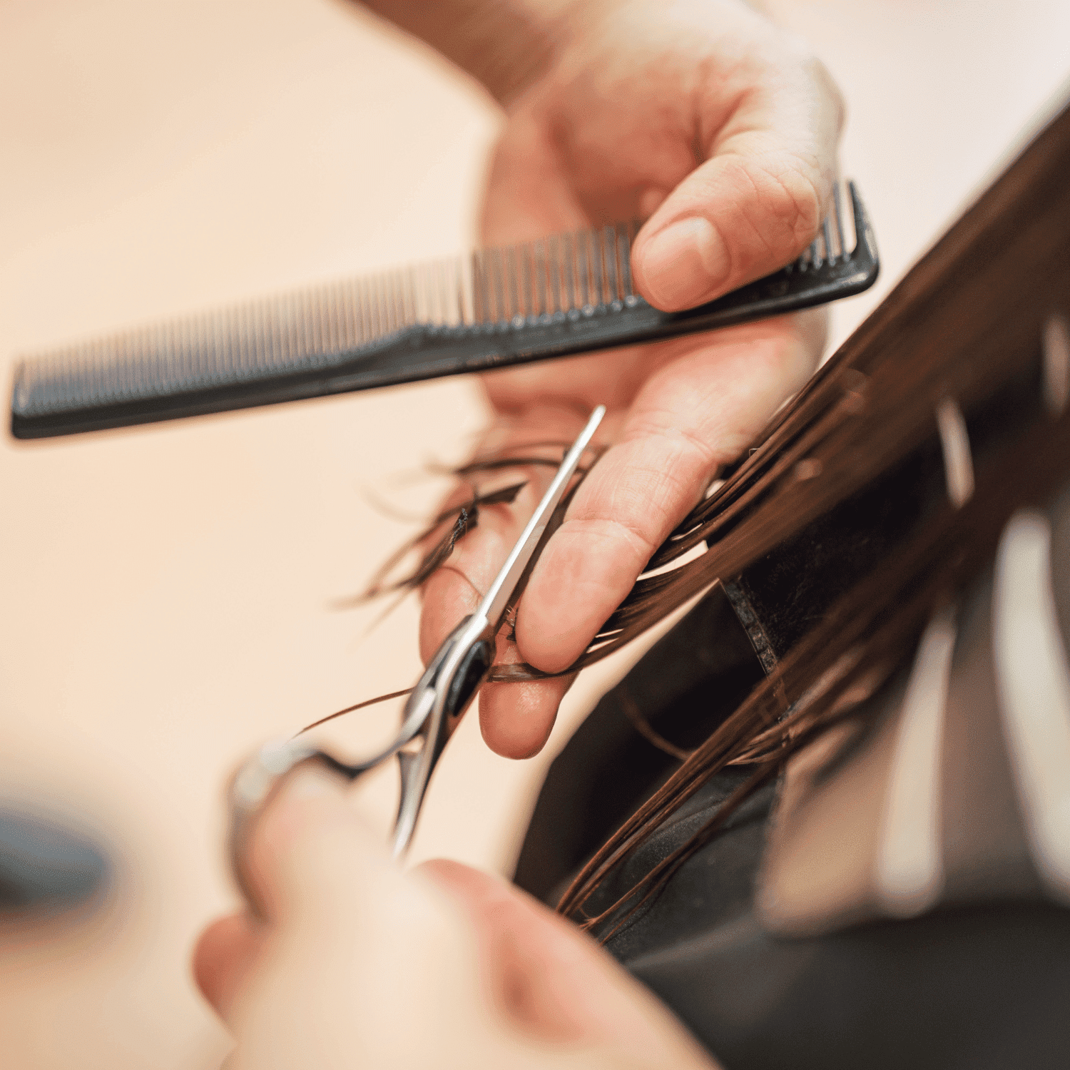 Hairdresser cutting brown hair with scissors and comb.