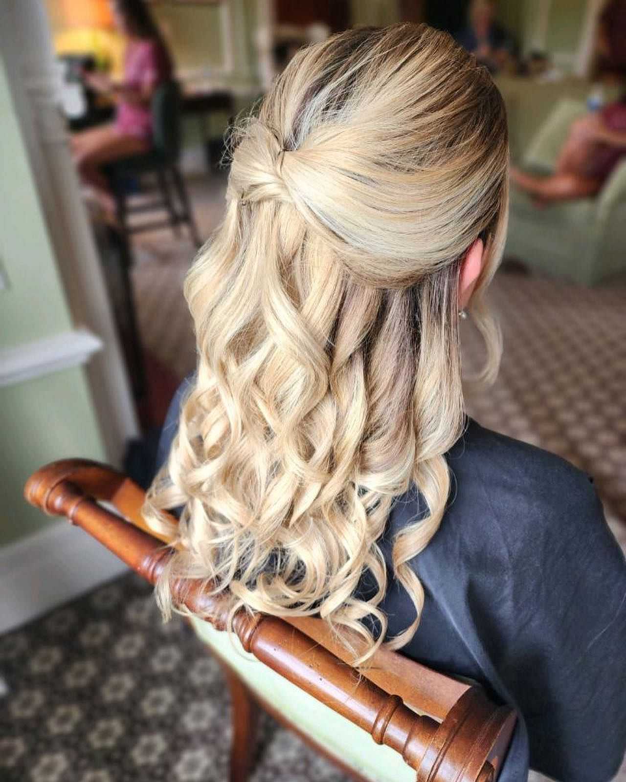 Blonde hair styled in an elegant half-up twist with cascading curls.